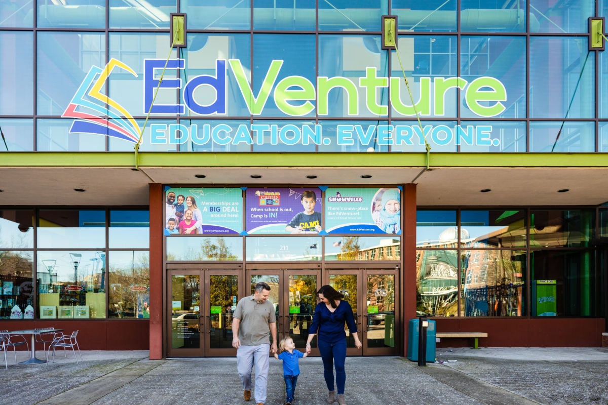Family of three walking out of Edventure Childrens Museum Text Reads: "EdVenture Education. Everyone."