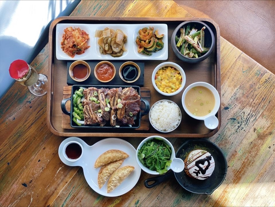 Overhead view of tray with a spread of Korean food, soup, and sides