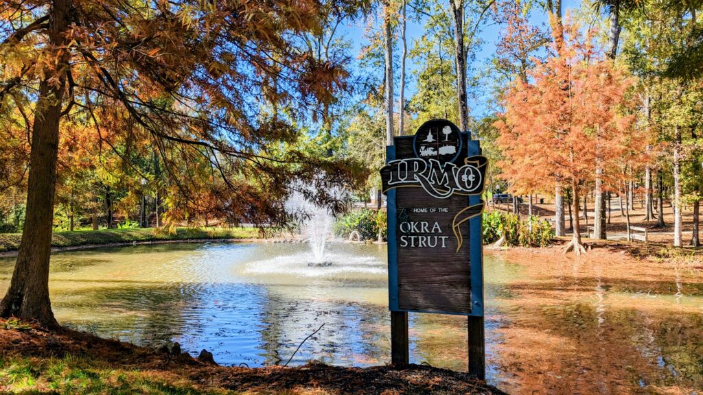 Welcome to Irmo sign with fountain and pond in background surrounded by trees