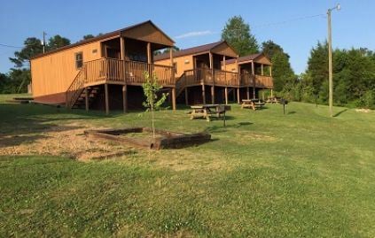 Three brown cabins set on a hill at Riverwinds Landing