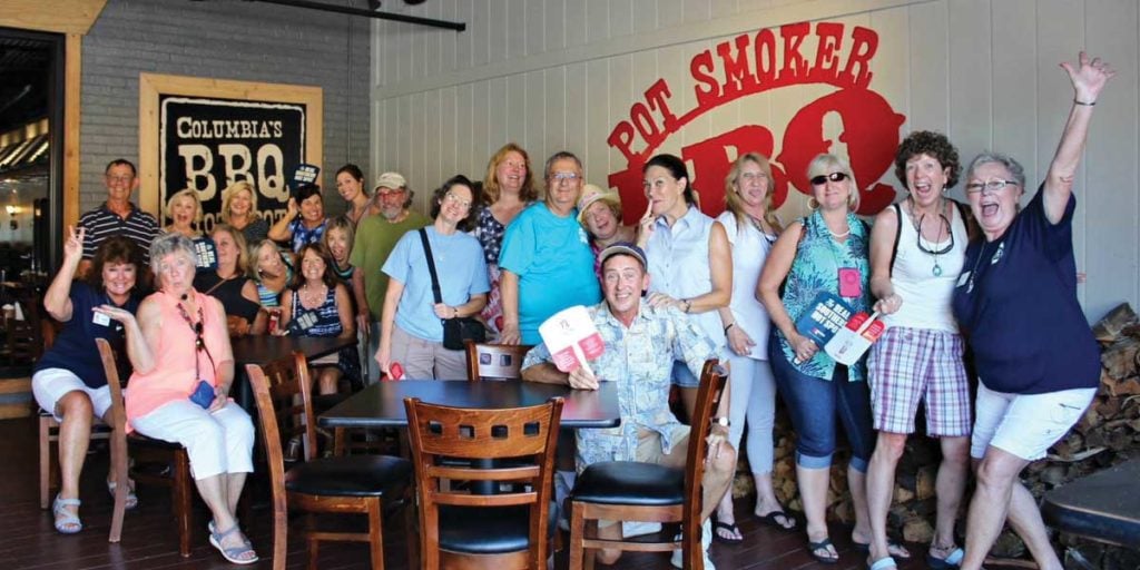 Group of twenty two people sitting on a porch of Pot Smoker BBQ in Columbia SC