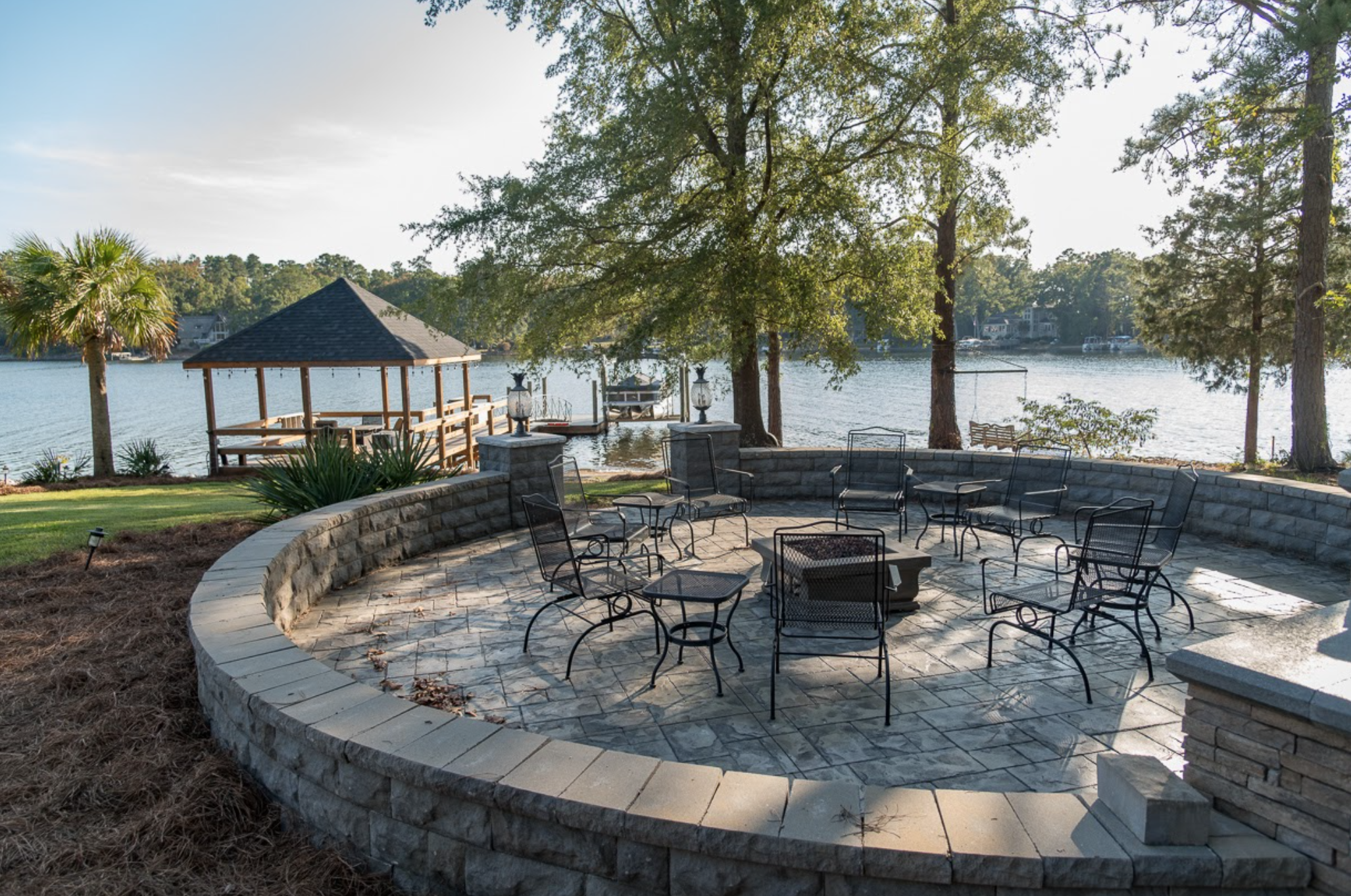 Patio with chairs and fire-pit overlooking Lake Murray with covered dock in the background