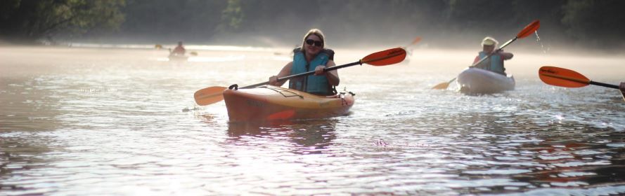 photo of female kayaker and 2 others in the background