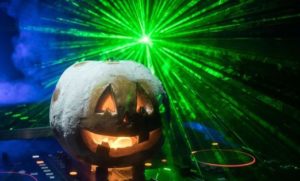 glowing pumpkin on a sound board with a green laser light beaming behind it