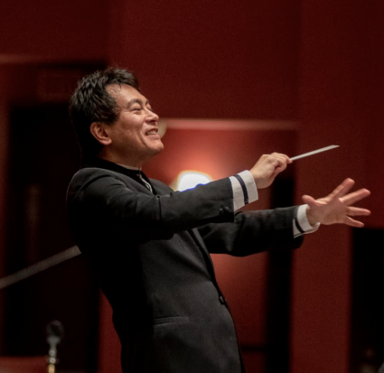 sc philharmonic conductor Morihiko Nakahara directing with a smile on his face