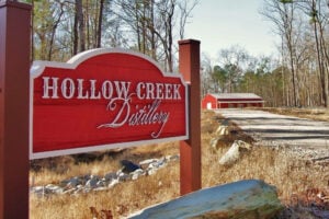 Hollow Creek Distillery sign showing the distillery in the background