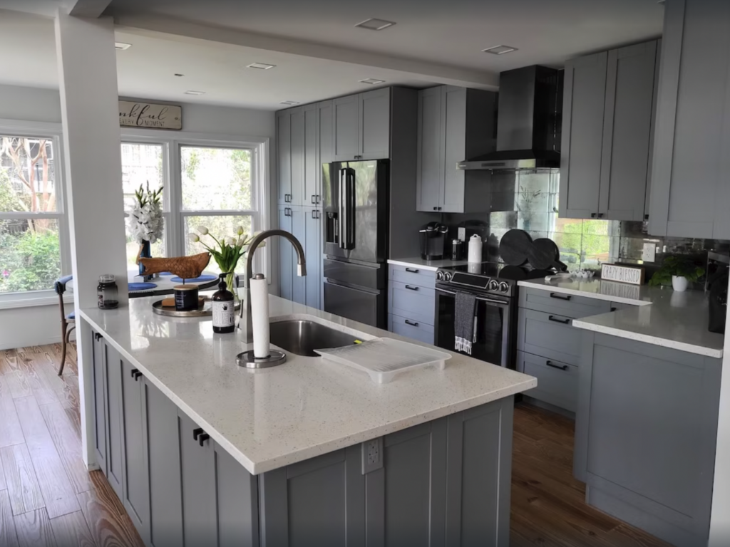 Gray painted kitchen with stone countertops and open floorplan