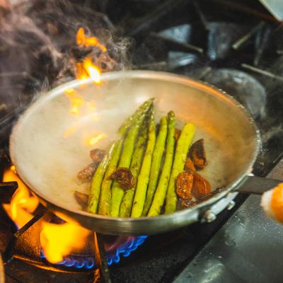 asparagus and garlic sauteed in a hot pan over a firey stone.