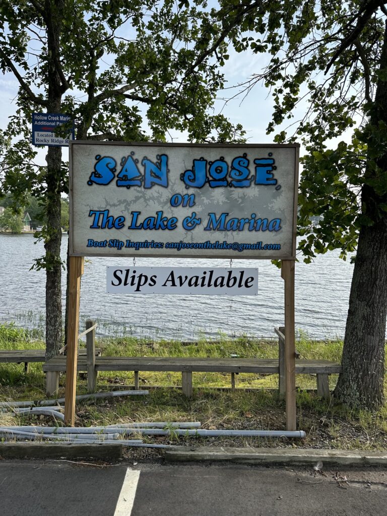 A sign displaying the words "San Jose, the Lake of Marina" against a scenic backdrop.