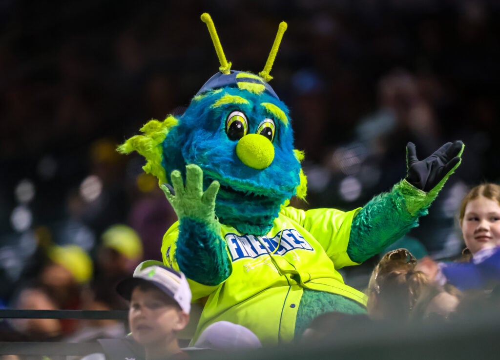 Mason the firefly mascot cheers on the crowd wearing a neon jersey.